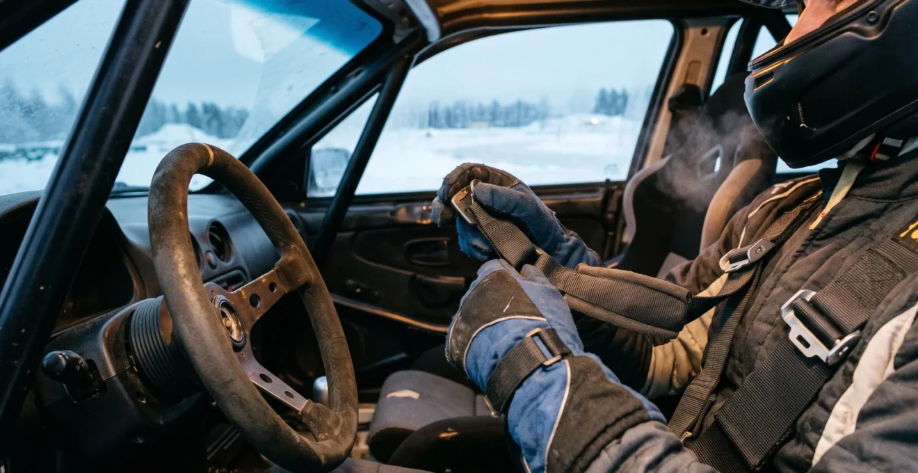 Un participant règle son harnais dans l'habitacle avant une session sur glace.